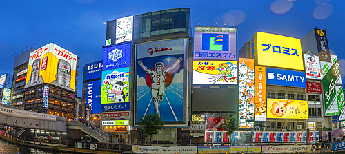 View of Glico sign of Dotonbori, vibrant entertainment district near the river at dusk, Osaka, Honshu, Japan, Asia