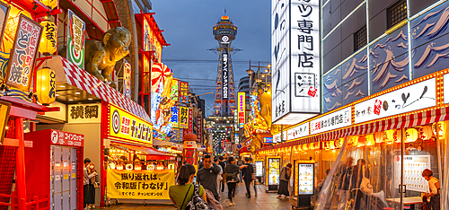 View of Tsutenkaku Tower and restaurants neon lights at dusk in the Shinsekai area, Osaka, Honshu, Japan