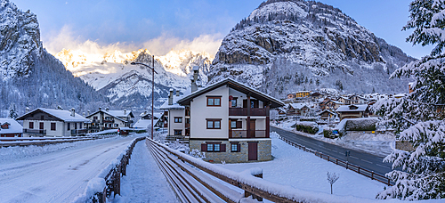 View of hotels, chalets and snow covered mountains in Courmayeur at sunrise during winter, Courmayeur, Aosta Valley, Italy, Europe