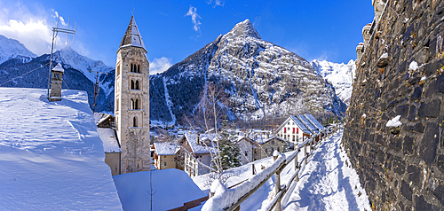 View of snow covered mountains, rooftops and Church of Saint Pantalon in Courmayeur during winter, Courmayeur, Aosta Valley, Italy, Europe