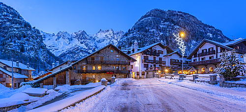 View of town centre and snow covered mountains in background at dusk, Courmayeur, Aosta Valley, Italy, Europe