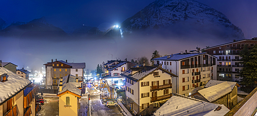 View of snow covered rooftops with mountainous background at dusk, Courmayeur, Aosta Valley, Italy, Europe