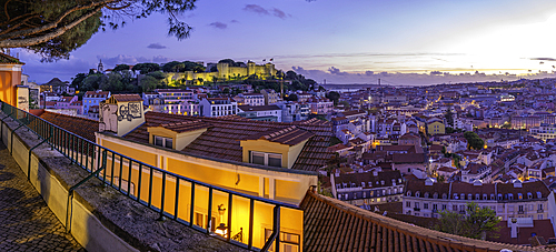 Panoramic view of Lisbon Castle from Miradouro da Senhora do Monte scenic point at dusk in the Alfama District, Lisbon, Portugal, Europe