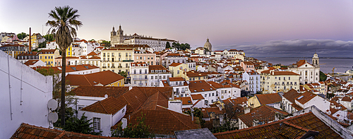 View of colourful buildings and red rooftops at sunset in the Alfama District, Lisbon, Portugal, Europe