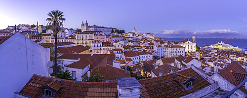 View of colourful buildings and red rooftops at dusk in the Alfama District, Lisbon, Portugal, Europe