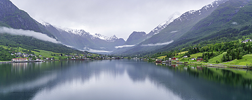 View of Olden village and mountains reflecting in Nordfjorden during summer, Norway, Scandinavia, Europe