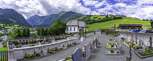 View of chapel and graveyard with mountains in background on a sunny day, Kaprun, Salzburg, Austria, Europe