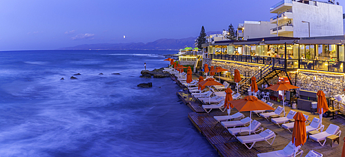 View of taverna overlooking the sea in Limenas Chersonisou at dusk, Crete, Greek Islands, Greece, Europe