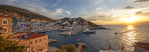 Panoramic view over the port and whitewashed houses on hillside at sunset, Hydra, Saronic Islands, Greek Islands, Greece, Europe