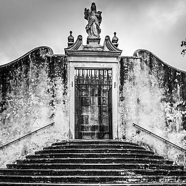 Weathered building exterior with statue above doorway, Coimbra, Coimbra District, Portugal