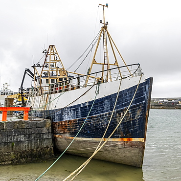 Ship moored in the harbour along the West Coast of Ireland at the mouth of the Galway Bay, Inishmore, Aran Islands, Kilronan, County Galway, Ireland