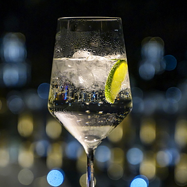 Carbonated water with lime wedge and ice cubes in a glass, Havana, Cuba