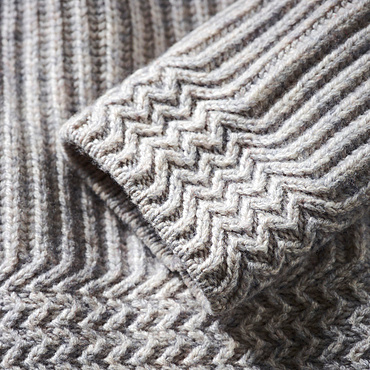 Extreme close-up of the cuff of a grey knit sweater; Studio