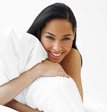 African woman hugging pillow