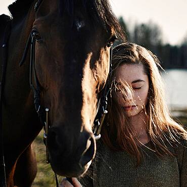 Caucasian woman walking with horse in field