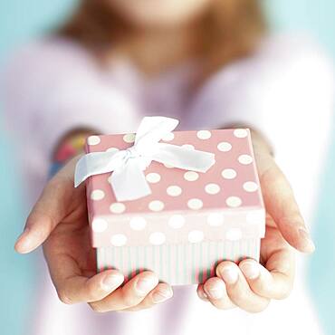 Close up of girl holding wrapped gift