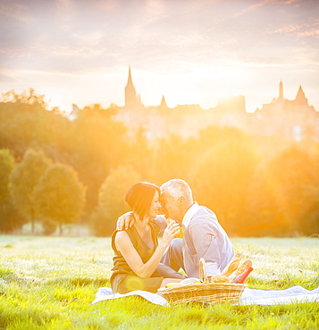 Caucasian couple enjoying picnic in grass