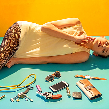 Caucasian woman laying on floor near wallet, gun and cell phone