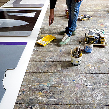 Caucasian artist painting with paint roller