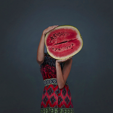 Caucasian girl holding enormous sliced watermelon