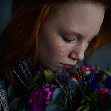 Caucasian teenage girl smelling flowers