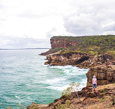 Australia, New South Wales, Port Macquarie, Woman standing on cliff and looking at view