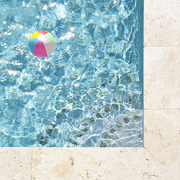 Beach ball floating in swimming pool