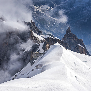 Looking down the ridge into the Vallee Blanche where a small group of climbers are heading into the Vallee below, Chamonix, Haute Savoie, Rhone Alpes, France, Europe