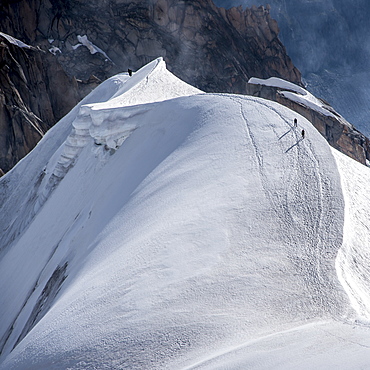 Looking down the ridge into the Vallee Blanche where a small group of climbers are heading into the Vallee below, Chamonix, Haute Savoie, Rhone Alpes, France, Europe