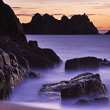 Early morning on the beach looking out towards Logan Rock at Porthcurno, Cornwall, England, United Kingdom, Europe