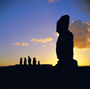 Silhouette of Ahu Tahai in foreground and behind the five moai (statues) of Ahu Vai Uri, Easter Island, Chile