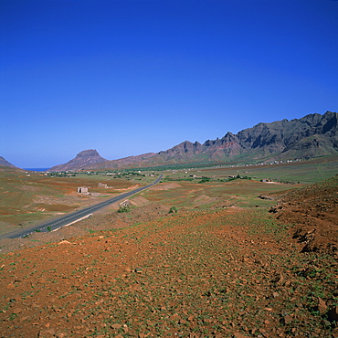 Road across a volcanic crater, with small buildings in the distance, inland on the island of Sao Vicente, Republic of Cape Verde Islands, Atlantic, Africa