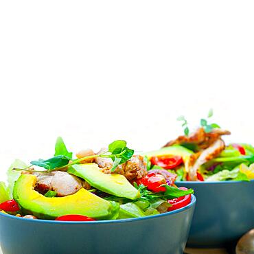 Fresh and healthy Chicken Avocado salad over rustic wood table