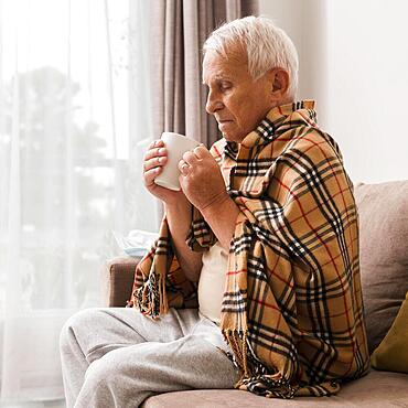 Side view sick man holding cup