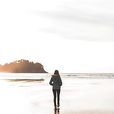 Young woman walking towards sea