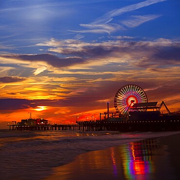 Santa Monica California sunset on Pier Ferrys wheel and reflection on beach wet sand