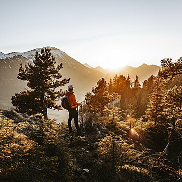 Hiker in the Allgäu at sunset in spring on the Zirmgrat near Pronten in the Allgäu