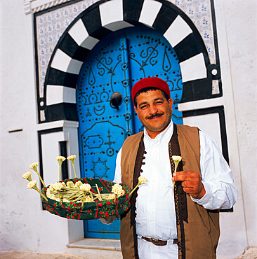 Jasmine seller in doorway, Sidi Bou Said, Tunisia, North Africa, Africa