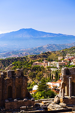 Mount Etna Volcano with ruins of Teatro Greco (Ancient Theatre) of Taormina in the foreground, Sicily, Italy, Europe 