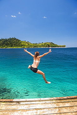 Woman jumping into the Pacific Ocean at Twin Beach, a tropical white sandy beach near Padang in West Sumatra, Indonesia, Southeast Asia, Asia