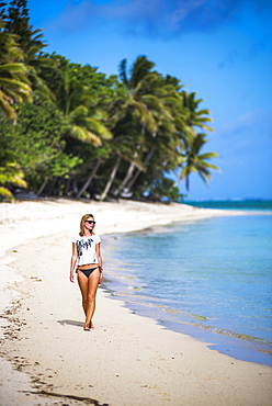 Woman walking along a tropical beach, Rarotonga Island, Cook Islands, South Pacific, Pacific