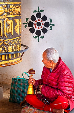 Worshipping Buddhist monk at Chimi Lhakhang Monastery, also known as the Fertility Temple, Punakha District, Bhutan, Asia