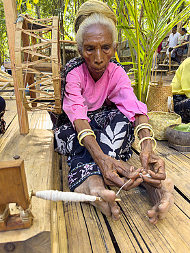 Woman making thread for textiles in the village of Liangawo, on Flores Island, Lesser Sunda Islands, Indonesia.