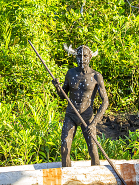 Male paddlers from the village of Per perform in a ritualistic greeting ceremony, Asmat Region, Papua, Indonesia.