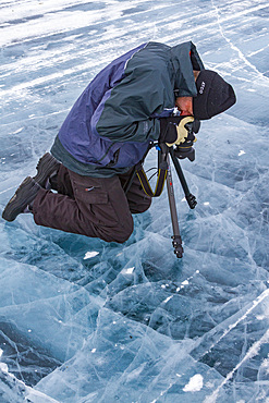 Canadian photographer Gilles Pucheu on the frozen solid Great Slave Lake, Northwest Territories, Canada.