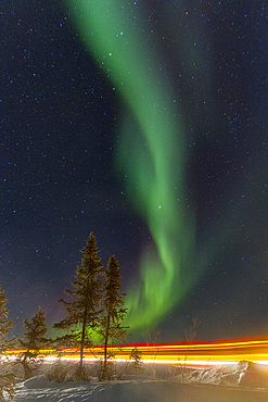 Long exposure of Jeep lights and Aurora Borealis, on the Great Slave Lake, Northwest Territories, Canada.