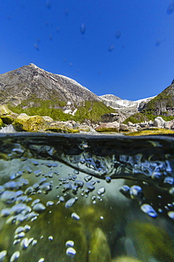 Above and below view of ice melt waterfall cascading down in Svartisen National Park, Melfjord, Nordfjord, Norway, Scandinavia, Europe