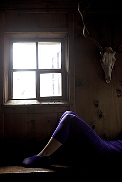 Young woman relaxing after skiing in a cosy alpine hut, See, Tyrol, Austria