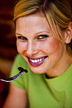 Young woman eating pancake with blueberries, lake Duisitzkar, Styria, Austria