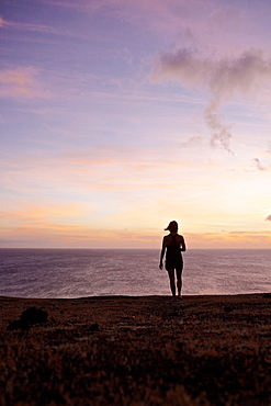 Woman looking at sunset over the ocean, Praia, Santiago, Cape Verde